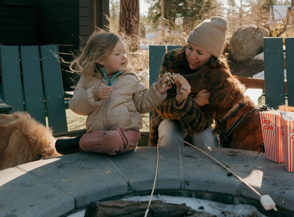 girl with her mom and dog making smores at station house inn fire pits