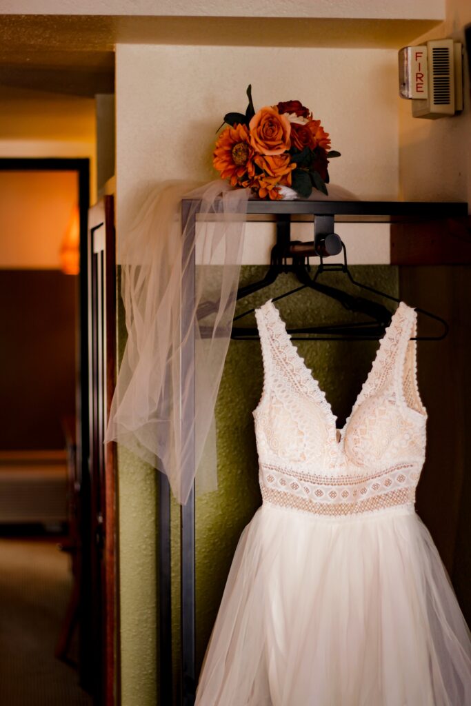 Wedding dress and bouquet hanging up in a hotel room in Lake Tahoe