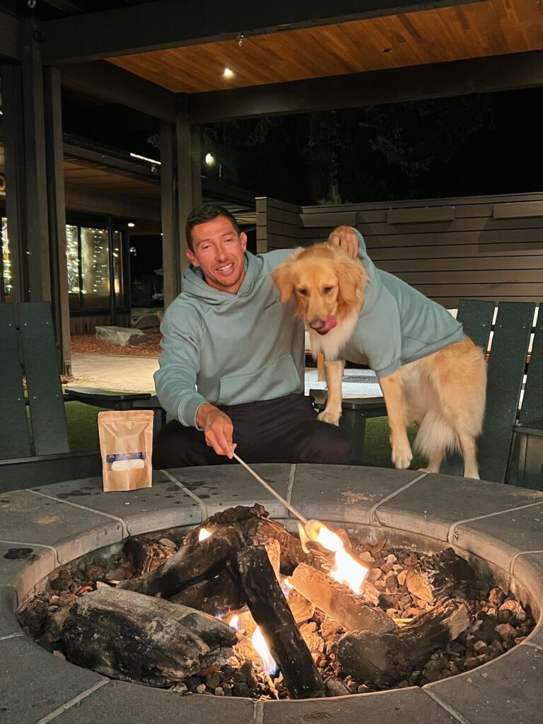 hotel guest and golden retriever dog make smores together at a fire pit at station house inn, a pet friendly tahoe experience