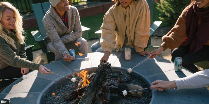 group of friends roasting marshmallows by the firepit at station house inn