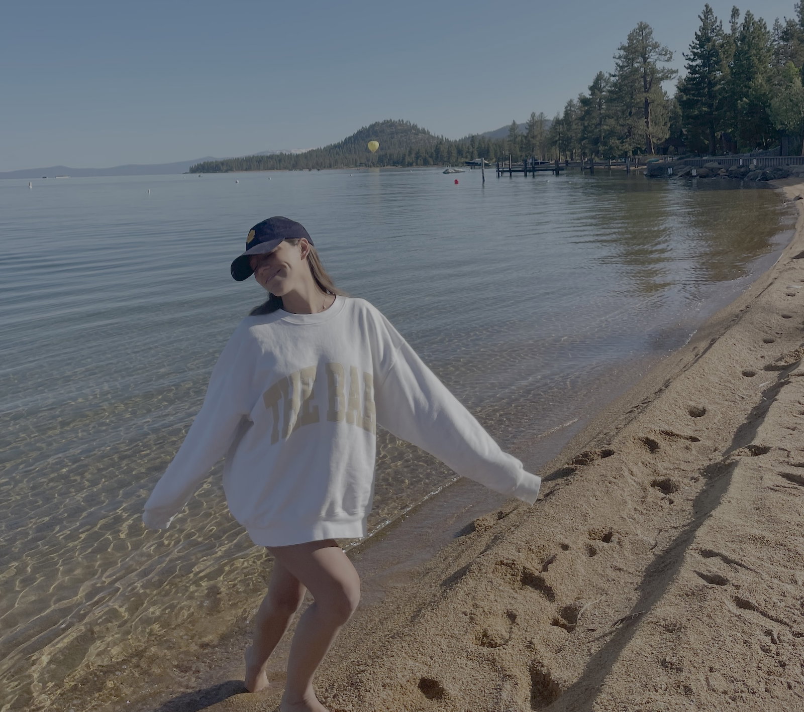 Guest walking along the soft sand at Lakeside Beach with Lake Tahoe's clear blue water