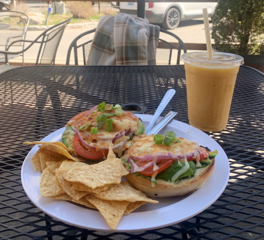 loaded bagel sandwich and smoothie at an outdoor patio table at sprouts in lake tahoe