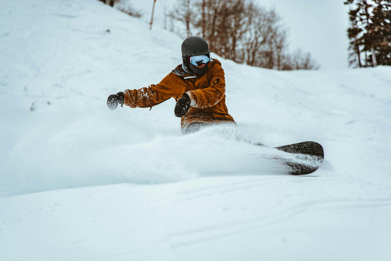 Snowboarder carving through fresh powder at a Lake Tahoe ski resort near South Lake Tahoe