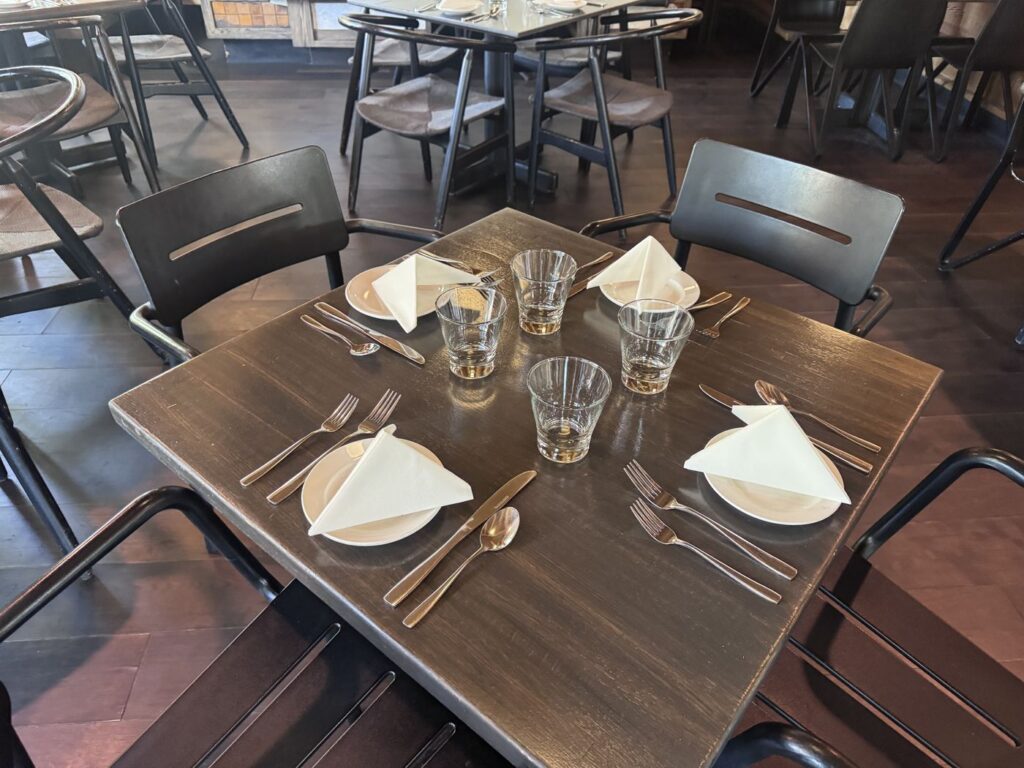 Dinner table setting with folded napkins and glassware at Toulouse