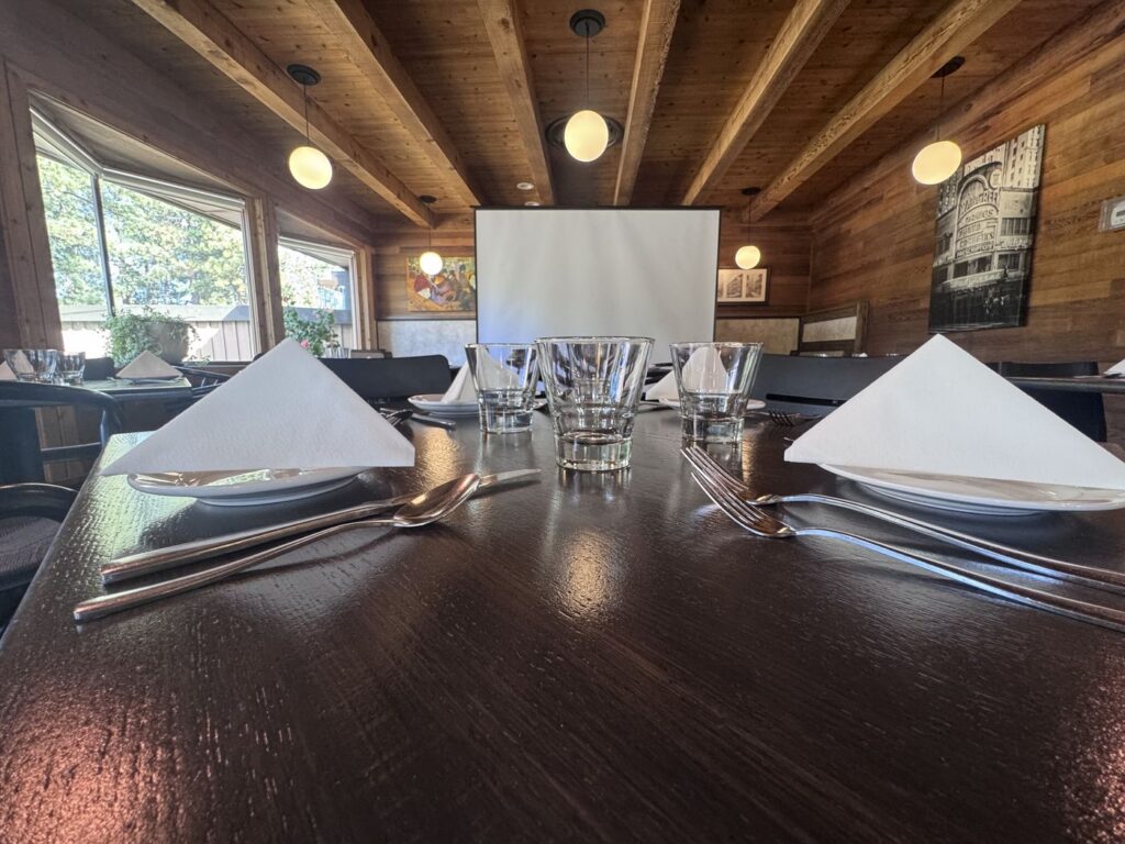 View from the table toward the projector screen at Toulouse private event space